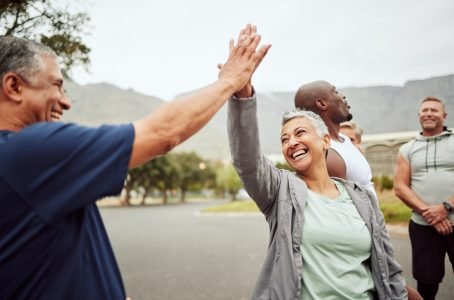 Fitness, high five and senior people or friends with support, accountability and teamwork in nature.